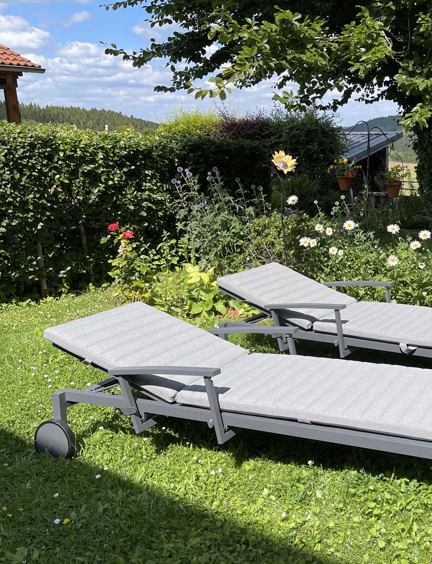Zwei bequeme Liegestühle im wunderschönen Ferienwohnungsgarten